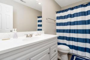 a bathroom with a white sink and a blue shower curtain at Peaceful Modern Home near Avon in Avon +40 photos