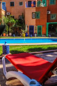 a red blanket sitting next to a swimming pool at 16 Riads in Marrakech