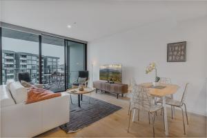 a living room with a couch and a table at City Center High-Rise Apartment with Parking in Canberra