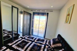 1 dormitorio con cama y ventana grande en F3 millenium, en Orán