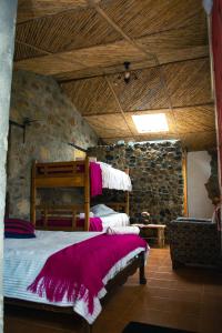 1 dormitorio con 1 cama en una pared de piedra en Termales SironaSpa, en Gama