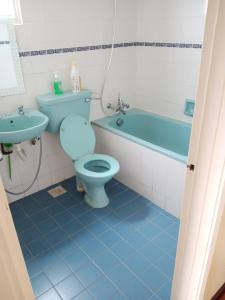 uma casa de banho com um WC azul e um lavatório. em Silverpart Resort Fraser Hill B5-6-1 Forest View High Floor No lift em Bukit Fraser