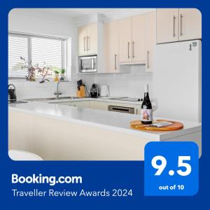 a kitchen with white cabinets and a bottle of wine at Amazing Ocean Views At This Exclusive 4 BR Holiday Home in McCracken