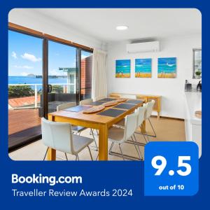 uma sala de jantar com uma mesa e cadeiras brancas em Amazing Ocean Views At This Exclusive 4 BR Holiday Home em McCracken