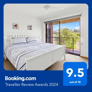 um quarto branco com uma cama e uma varanda em Amazing Ocean Views At This Exclusive 4 BR Holiday Home em McCracken