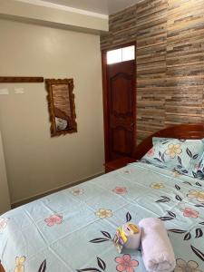 Una cama con un edredón azul con flores. en HOSTAL LOS NOGALES en Aguaytía