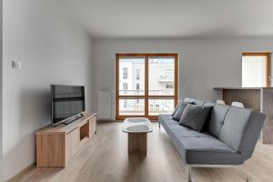 sala de estar con sofá y TV en Mila Baltica by Grand Apartments, en Gdansk