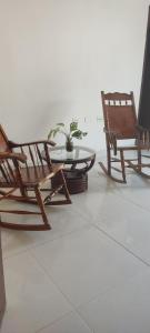 een groep stoelen en een tafel met een potplant bij Casa Katiuska in Mompos