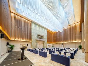 Una gran sala con filas de sillas y un podio. en Holiday Inn Express Beijing Conference Center by IHG, en Beijing