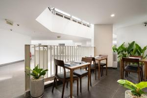 un comedor con mesas, sillas y plantas en Convinia Luxury The Peak Midtown, en Ho Chi Minh