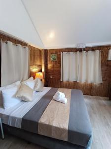 a bedroom with a large bed with two towels on it at Caliraya Mountain Lake Resort in Cavinti