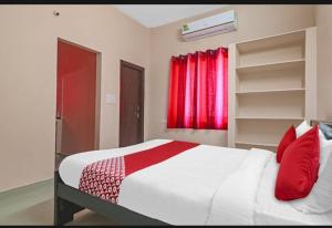 a bedroom with a large white bed with red pillows at hotel high 5 in Hyderabad