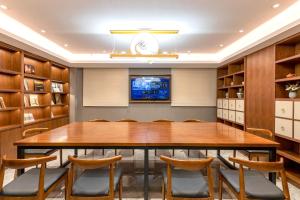 a conference room with a large wooden table and chairs at Nostalgia S Hotel - North Railway Station Kunming in Kunming