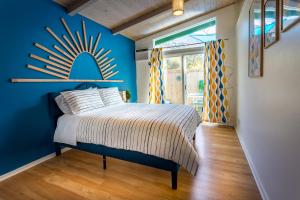 Un dormitorio con una cama con una pared azul. en Retro House on the River !, en Three Rivers