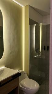 y baño con aseo, ducha y lavamanos. en Sonata 44 Hotel Laureles en Medellín