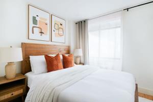 1 dormitorio con 1 cama blanca grande con almohadas de color naranja en 75-2A furnished 1BR W D Elev central park, en Nueva York