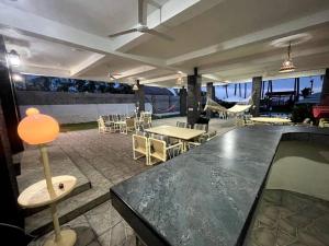 un restaurante con mesa, sillas, mesas y techo en Casa BLUE paradise HOUSE, en El Corozal