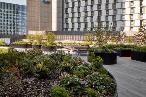 a courtyard with plants and tables and a building at Urban Rest Stratford Apartments in London