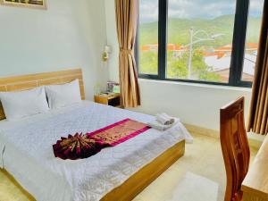 a bedroom with a bed and a large window at Chau Gia Hotel in Vĩnh Hy