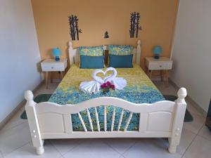 a bedroom with a white bed with two swans on it at BELLA in Gros-Morne