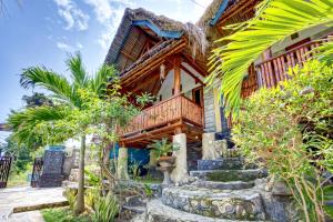 ein Holzhaus mit Balkon und einigen Bäumen in der Unterkunft Bagus Cottage in Nusa Penida + 44 Fotos