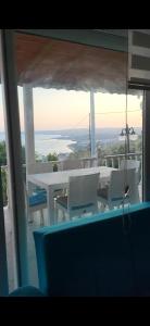 a table and chairs on a balcony with a view of the ocean at Rüyakent Sea Panorama in Didim