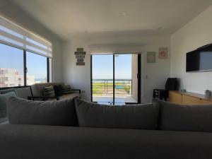 sala de estar con sofá y TV de pantalla plana en SUNRISE Apart, en Playas