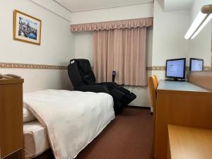 Habitación de hotel con cama y escritorio con ordenador en Hotel Alpha-One Niigata en Niigata