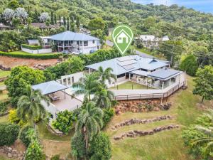 an aerial view of a house with a mountain at The Orchard House - Luxury Tropical Villa in Redlynch