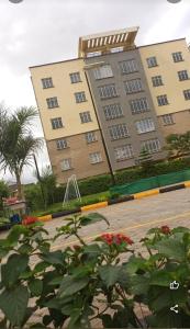 a large building with red flowers in front of it at Luxury Homes in Nairobi in Athi River
