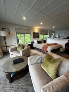 uma grande sala de estar com uma cama e um sofá em Queenstown House Bed & Breakfast and Apartments em Queenstown