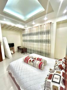 - une chambre avec un grand lit blanc et une fenêtre dans l'établissement Cherry Homestay - Hoàng Đế motel, à Chau Doc