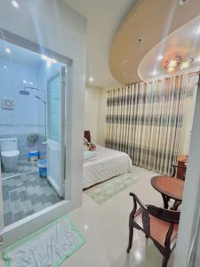 a bedroom with a bed and a table and a mirror at Cherry Homestay - Hoàng Đế motel in Chau Doc