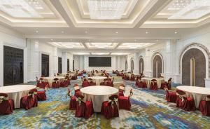 a banquet hall with tables and chairs and a projection screen at Tavia Heritage Hotel in Jakarta +29 photos