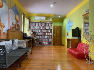een woonkamer met boekenplanken en een rode bank bij Mei Jen House B&B 民宿 in Yuchi