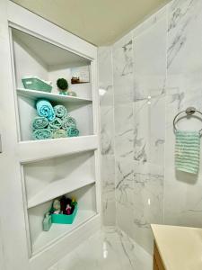 a bathroom with white shelves and a shower at House 2 Bedrooms with King Queen and Sofa Bed near Airport and Downtown Seattle in Seattle