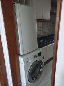 a washing machine with a microwave on top of it at Hotel sol vitória Marina in Salvador