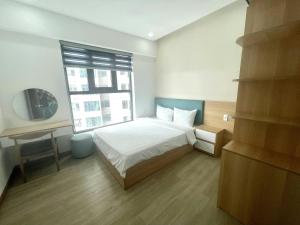 - une chambre avec un lit, une fenêtre et un bureau dans l'établissement Nha Trang Ocean View Apartment, à Nha Trang