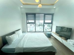 une chambre avec un lit et une télévision à écran plat dans l'établissement Nha Trang Ocean View Apartment, à Nha Trang