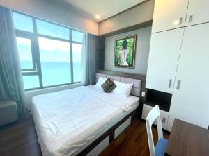 ein Schlafzimmer mit einem Bett und einem großen Fenster in der Unterkunft Nha Trang Ocean View Apartment in Nha Trang