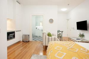 a white room with a bed and a living room at Funky Inner West Studio with Private Patio in Sydney