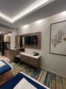 a room with a bed and a tv and a bathroom at بوابة منى الذهبي in Al ‘Azīzīyah
