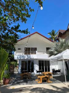 una casa blanca con mesas de picnic delante en Castle Rock Apartelle en Boracay