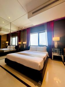 ein Schlafzimmer mit einem großen Bett und einem großen Fenster in der Unterkunft Sway Suites in Manama