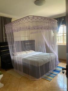 a bed with a canopy in a bedroom at Kampala Comfort living in Kampala