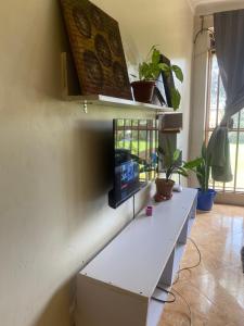 a white desk with a tv on a wall at Kampala Comfort living in Kampala