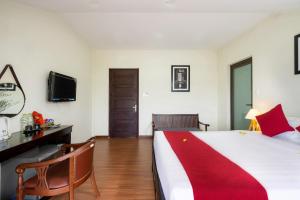 a bedroom with a large bed with a red blanket on it at Ancient River Villa in Hoi An