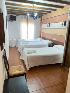 a row of beds in a room with a room with at Hostal El Descanso Del Emperador in Jarandilla de la Vera