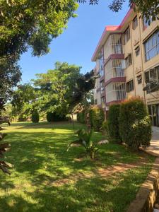 a apartment building with a palm tree in a yard at Kampala Comfort living in Kampala