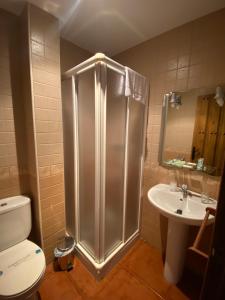 a bathroom with a shower and a toilet and a sink at Hostal El Descanso Del Emperador in Jarandilla de la Vera